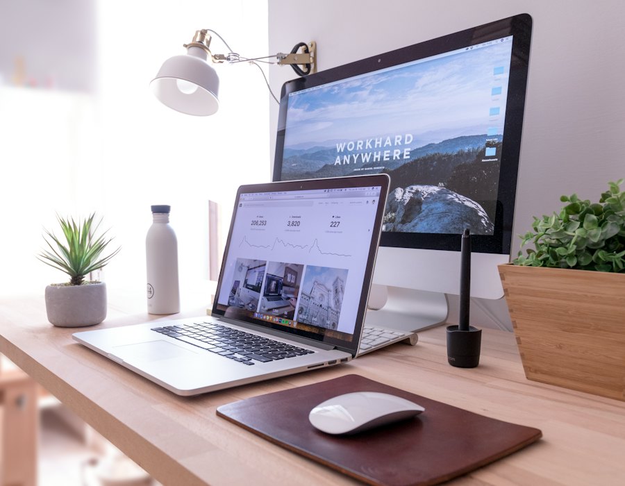 میز کار خانگی با لپ‌تاپ و مانیتور کنار پنجره